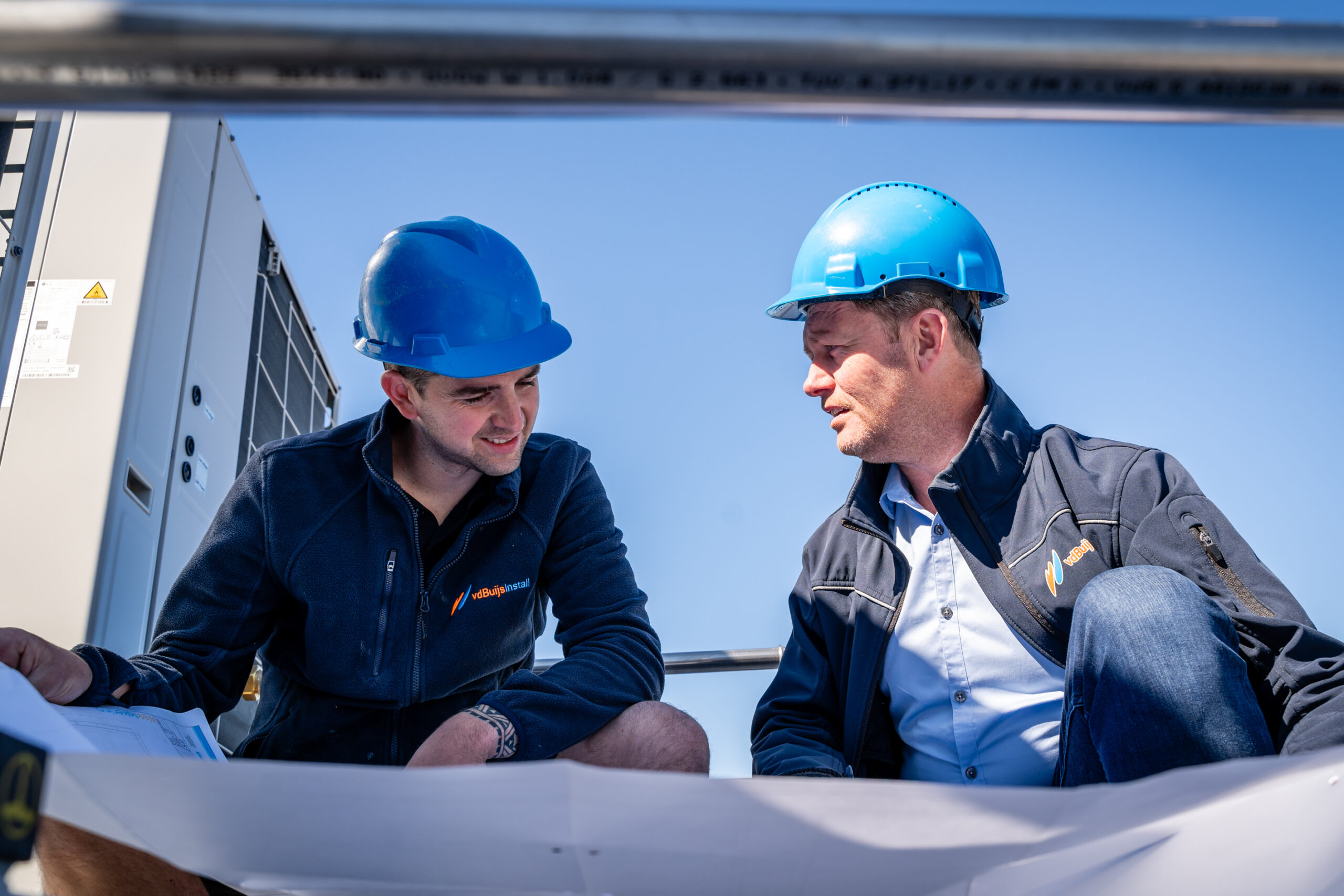 Projectleider en monteur bekijken een bouwtekening op de bouwplaats
